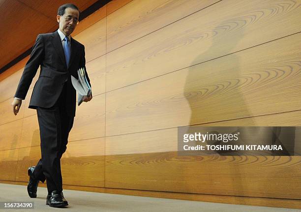 Governor of the Bank of Japan Masaaki Shirakawa leaves the room after his monthly press conference at its headquarters in Tokyo on November 20, 2012....