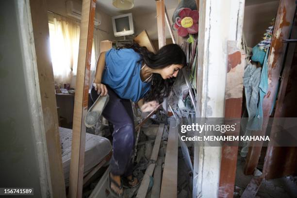 Sapir Hakmon retrieves one of her shoes from her damaged home after it was hit by a rocket launched by Palestinian militants from the Gaza Strip in...