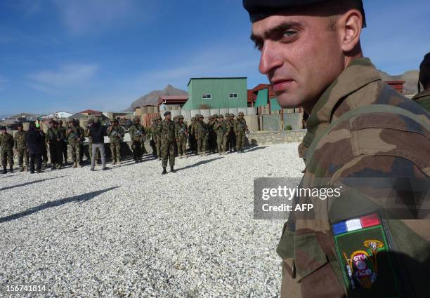 French soldier looks on as Afghan National Army soldiers stand in formation during a handover ceremony at the French military Camp Nijrab in Nijrab...