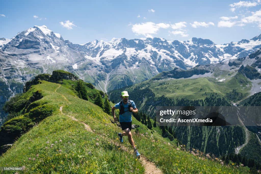 Trail runner sobe caminho alpino na paisagem montanhosa suíça