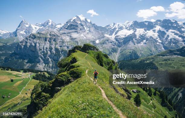 trail runner ascends alpine path in swiss mountain landscape - mountain path stock pictures, royalty-free photos & images