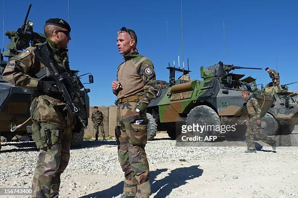 French soldiers talk near their armoured vehicles before departing for Kabul following a handover ceremony at the French military Camp Nijrab in...