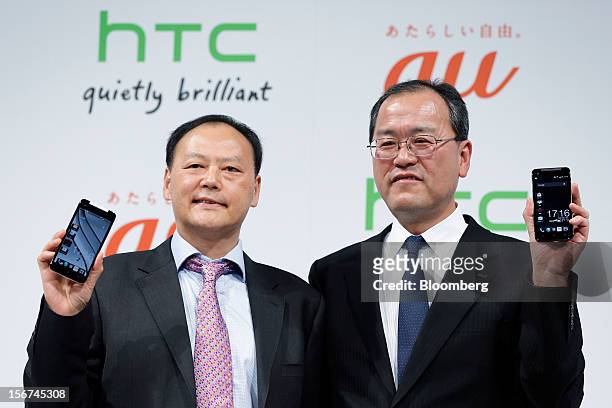 Peter Chou, chief executive officer of HTC Corp., left, stands with Takashi Tanaka, president of KDDI Corp., as they hold the HTC J Butterfly...