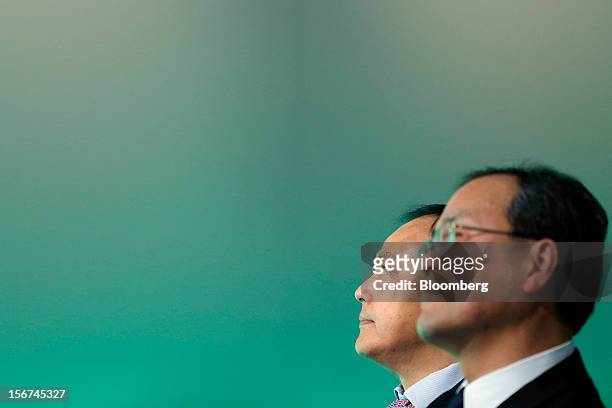 Peter Chou, chief executive officer of HTC Corp., left, stands with Takashi Tanaka, president of KDDI Corp., during the launch of the HTC J Butterfly...