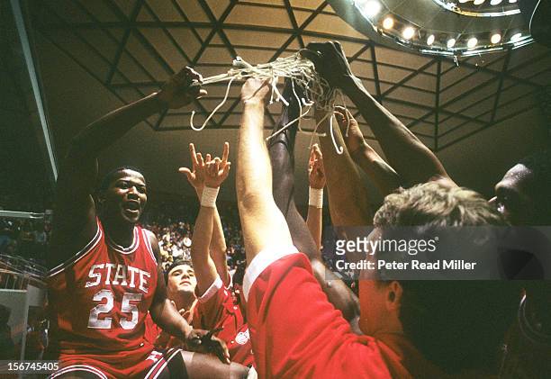 Playoffs: Closeup of North Carolina State Dereck Whittenburg victorious, holding net with teammates after winning game vs Virginia at Dee Events...