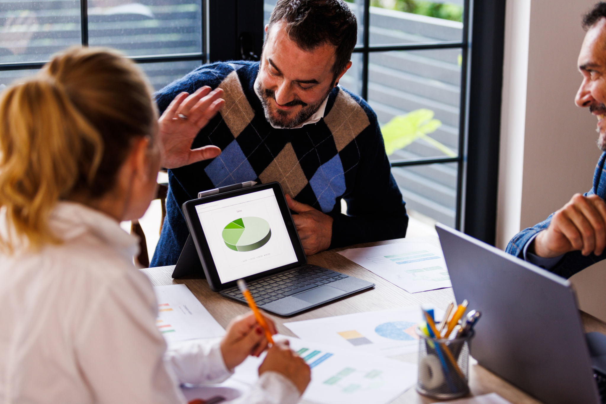 Businessman showing a chart on digital tablet during a project meeting Businessman showing a chart on digital tablet during a project meeting