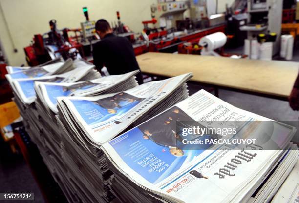 Worker piles up copies of French daily newspaper "Le Monde" in the printing house of "Le Midi Libre", the southwestern newspaper on November 20, 2012...