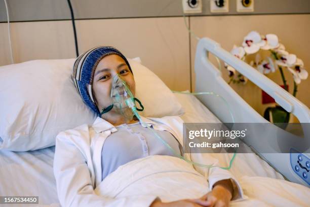 woman with ventilator mask on hospital bed - hospital ventilator stock pictures, royalty-free photos & images