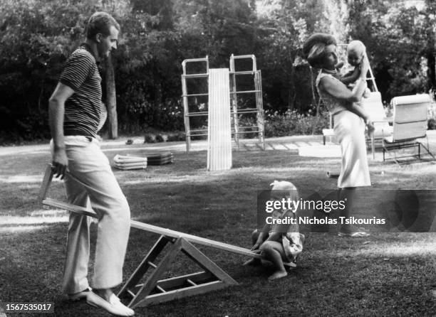 Spanish Royal Juan Carlos, Prince of Asturias with daughter Infanta Dona Elena of Spain sitting on a seesaw and Greek Royal Princess Sophia of Spain...