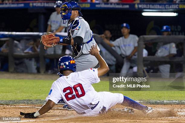 Concepcion Rodriguez of Team Panama slides safely into home as Janior Montes of Team Nicaragua waits for the throw in the bottom of the fourth inning...