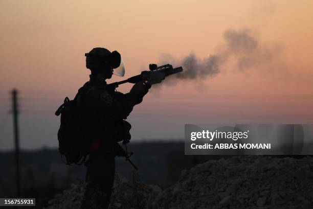 An Israeli border guard fires a tear gas canister during clashes with Palestinians following the funeral of a policeman who died two days ago at a...