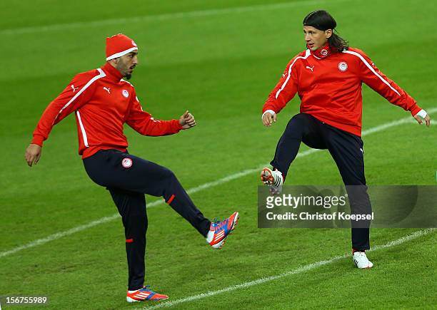 Kostas Mitroglou and Marko Pantelic of Olympiacos Piraeus stretch during the training session at Veltins Arena ahead of the UEFA Champions League...