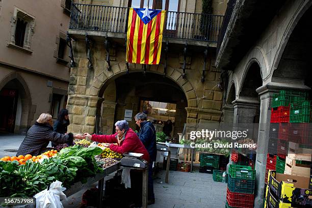 People buy vegetables beneath a pro-independent Catalonia flag in a green market on November 20, 2012 in Vic, Spain. Catalans will be voting in...