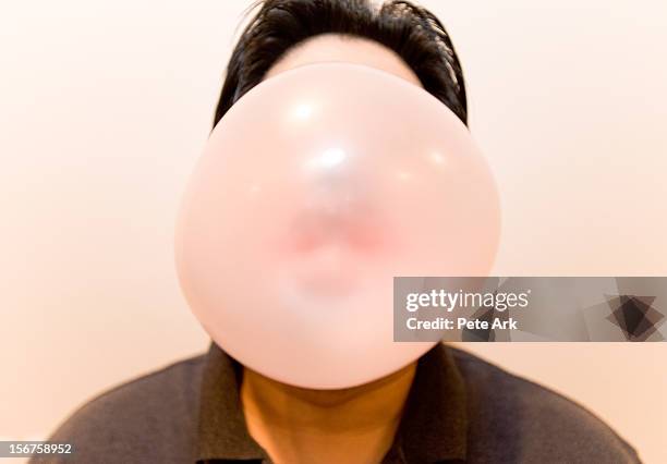 man blowing a big bubble with bubble gum. - big bubble foto e immagini stock