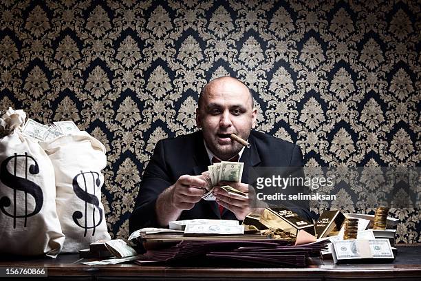 stereotype reiche mann posieren mit geld taschen, zählen-dollarnoten - cigar stock-fotos und bilder