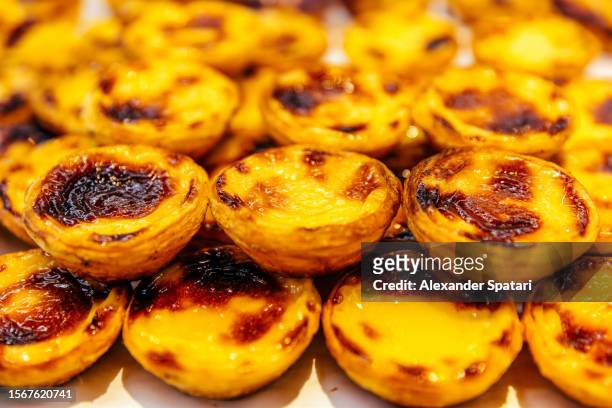 pastel de nata tarts for sale at the bakery, close-up - pastel de nata stock pictures, royalty-free photos & images
