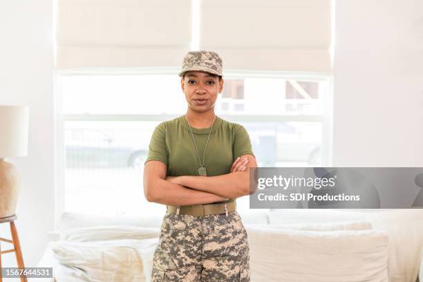 proud female military service member stands with her arms crossed to have her photo taken - black army soldier stock pictures, royalty-free photos & images