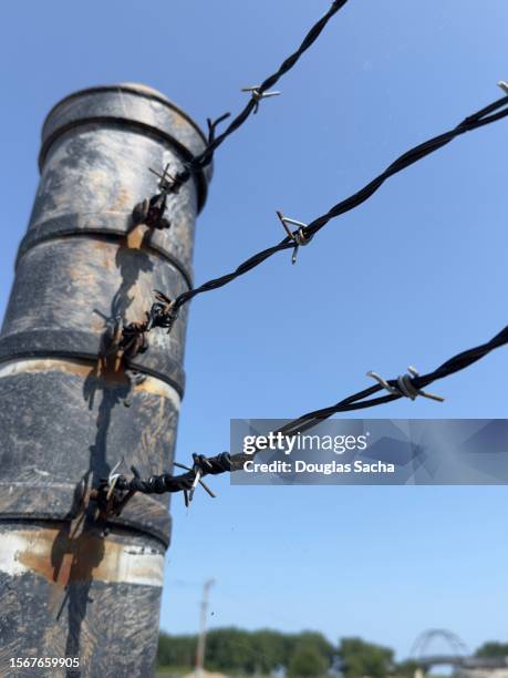 barbed wire on a fence post - chain fence stock-fotos und bilder