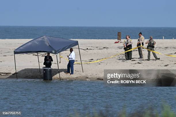 Officials stand next to a barrel where a body was discovered in Malibu Lagoon State Beach, California on July 31, 2023. A body stuffed in a barrel...