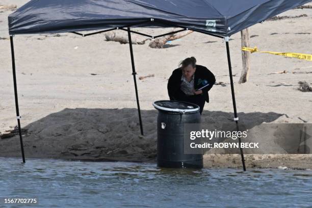 An official stands next to a barrel where a body was discovered in Malibu Lagoon State Beach, California on July 31, 2023. A body stuffed in a barrel...