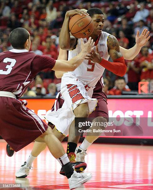 Maryland's Nick Faust splits Layfayette defenders Tony Johnson, left, and Seth Henrichs on his way to the basket during first-half action at the...