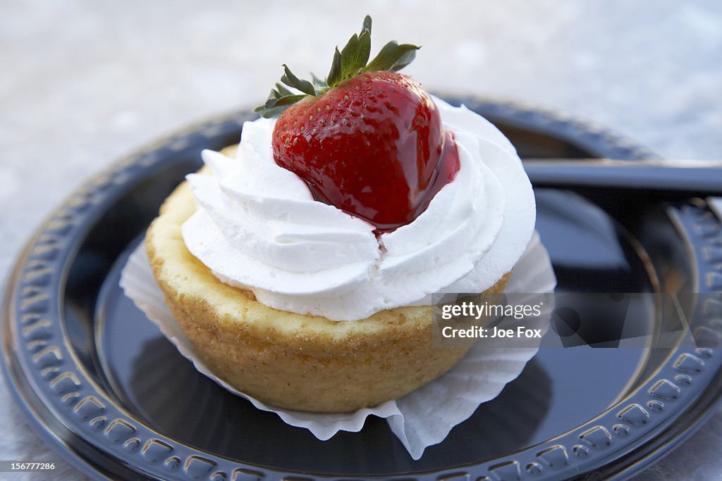 Strawberry cheesecake pastry on a plastic plate