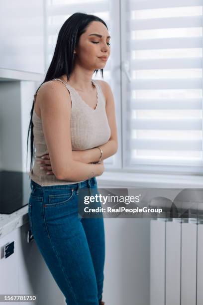 woman cares for herself amid stomach problems at home - irritable bowel syndrome stock pictures, royalty-free photos & images