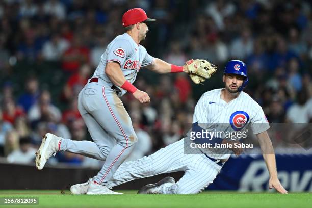 Spencer Steer of the Cincinnati Reds tags out Trey Mancini of the Chicago Cubs to begin a double play in the fourth inning at Wrigley Field on July...
