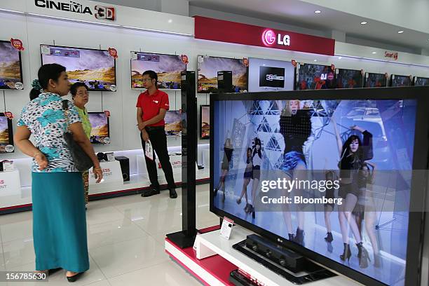 Customers look at LG Electronics Inc. Televisions displayed for sale at the company's retail store in Yangon, Myanmar, on Tuesday, Nov. 20, 2012....