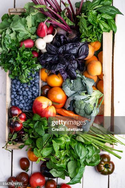 plant based food, fresh organic fruits, berries, vegetables, and herbs in wooden box, high angle view - colorful vegetables summer stock-fotos und bilder