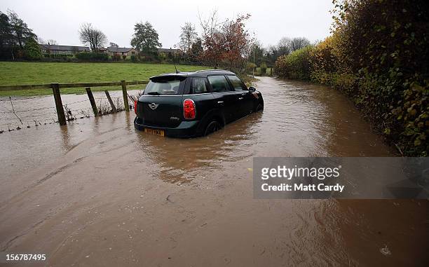 Car sits stuck in flood water on a lane in the village of Chilcompton on November 21, 2012 near Wells, England. Heavy rain overnight has brought...