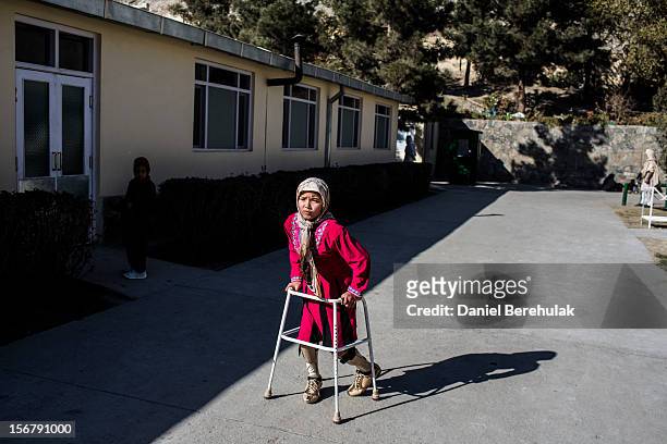 Merzia from Wardak province, suffering from congenital birth defects exercises with the aid of a walker at the International Committee of the Red...