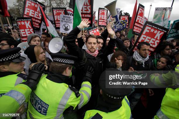 Protesters scuffle with police and shout slogans during a demonstration against education cuts, tuition increases and austerity outside the Houses of...