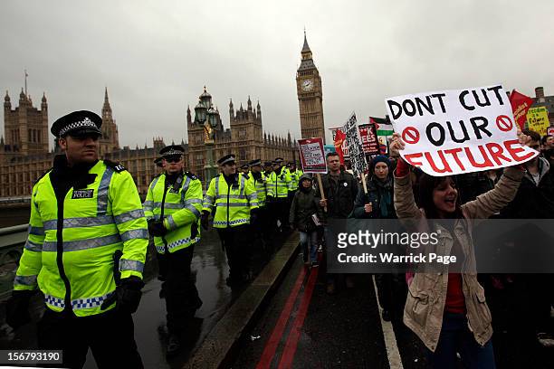 Protesters march beside a line of police officers during demonstration against education cuts, tuition increases and austerity, by the Houses of...
