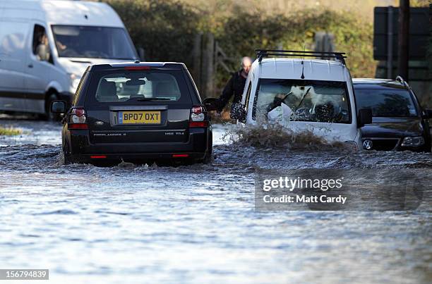 4x4 car passes abandoned cars left on a flooded road close to the village of North Curry on November 21, 2012 near Taunton, England. Heavy rain...