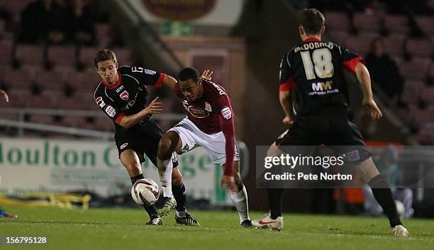 Ishmel Demontagnac of Northampton Town looks to move with the ball between Andy Fleming and Gary McDonald of Morecambe during the npower League Two...