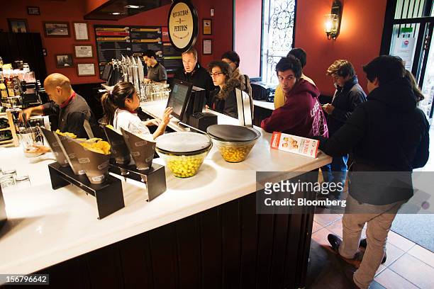Customers queue to place food orders at the counter of a 100 Montaditos restaurant in Madrid, Spain, on Wednesday, Nov. 21, 2012. The Madrid-based...