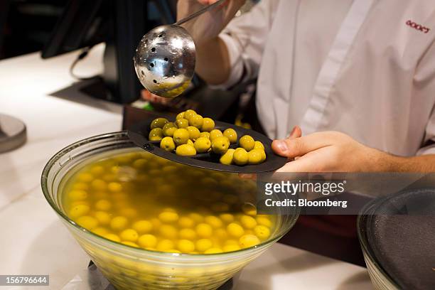An employee prepares a customer's order of green olives at a 100 Montaditos restaurant in Madrid, Spain, on Wednesday, Nov. 21, 2012. The...