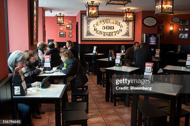 Customers sit and dine at tables inside a 100 Montaditos restaurant in Madrid, Spain, on Wednesday, Nov. 21, 2012. The Madrid-based chain in January...