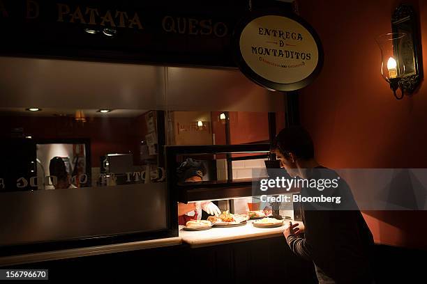 Customer collects his food order from the counter at a 100 Montaditos restaurant in Madrid, Spain, on Wednesday, Nov. 21, 2012. The Madrid-based...