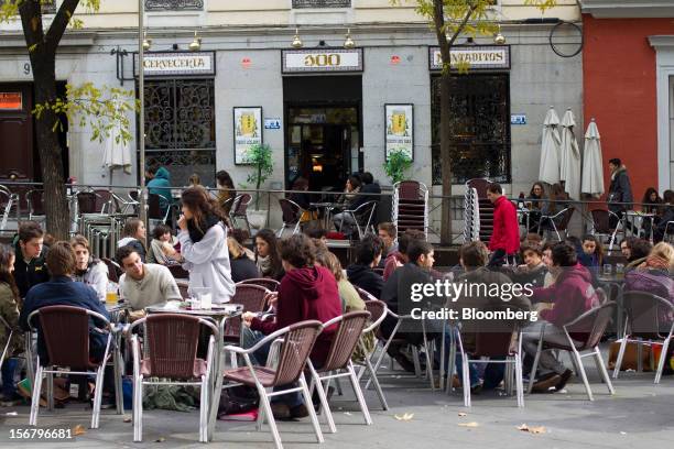 Customers sit at outdoor tables on the terrace of a 100 Montaditos restaurant in Madrid, Spain, on Wednesday, Nov. 21, 2012. The Madrid-based chain...