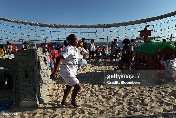 Maid carries a child at the Baixo Bebe beach playground in Rio de Janeiro, Brazil, on Monday, Nov. 19, 2012. With unemployment in Latin America’s...