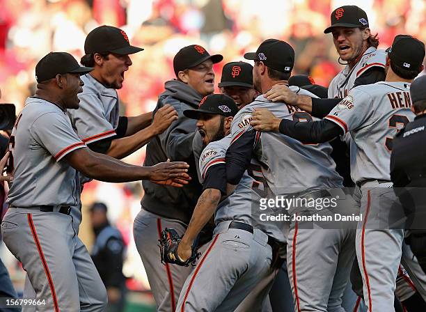 Members of the San Francisco Giants surround Sergio Romo after defeating the Cincinnati Reds in Game Five of the National League Division Series at...