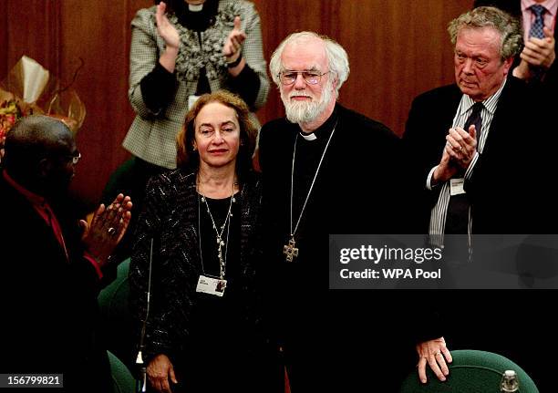 Dr Rowan Williams, the outgoing Archbishop of Canterbury, and his wife Jane take the applause during his farewell tributes at a meeting of the...
