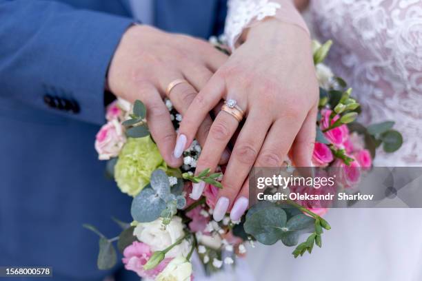 hands of married couple wearing wedding rings - married stock pictures, royalty-free photos & images