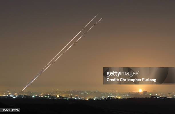 During the last hour of hostilities, militants launch rockets from Gaza City as an Israeli bomb explodes on the horizon on November 21, 2012 on...