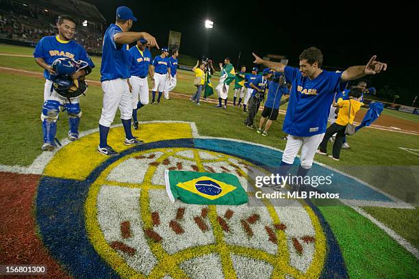 Rafael Fernandes of Team Brazil celebrates by placing a Brazilian flag on the World Baseball Classic logo on the field after winning Game 6 of the...