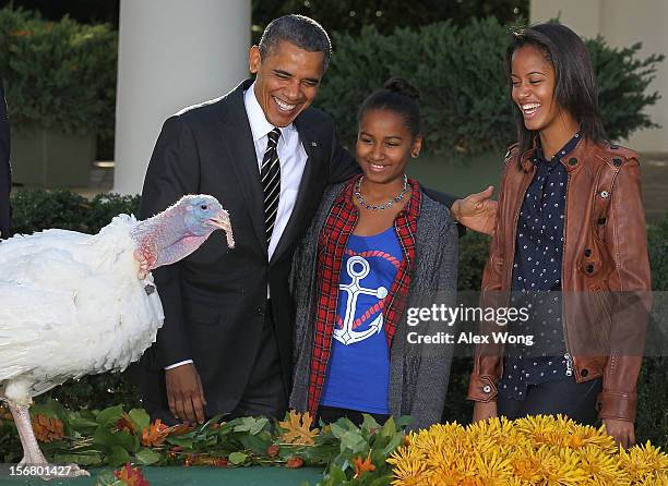 President Barack Obama and daughters Sasha Obama and Malia Obama share a moment as he pardons the 2012 National Thanksgiving Turkey Cobbler during a...