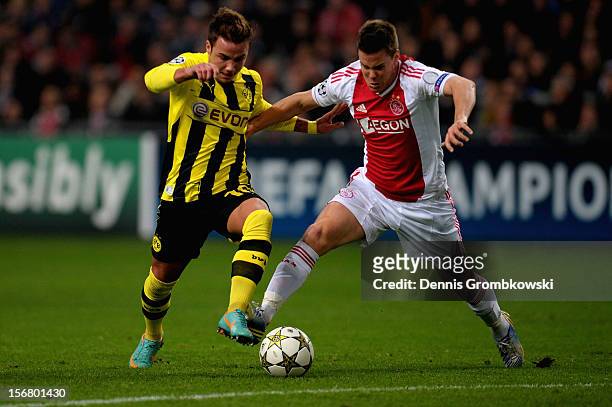 Mario Goetze of Dortmund is challenged by Niklas Moisander of Amsterdam during the UEFA Champions League Group D match between Ajax Amsterdam and...