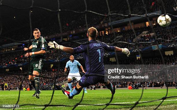 Karim Benzema of Real Madrid scores the opening goal past Joe Hart of Manchester City during the UEFA Champions League Group D match between...